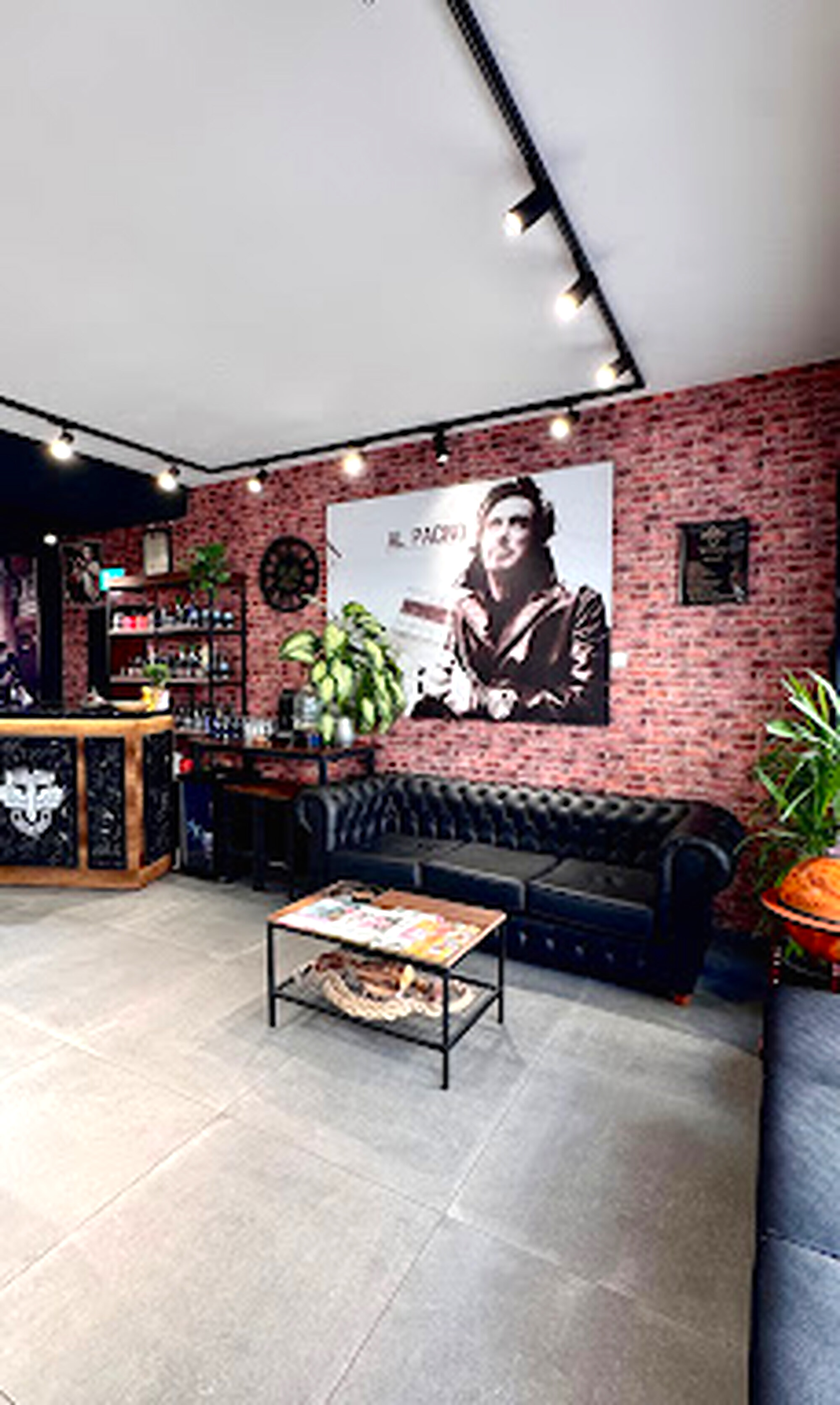 Lounge-Bereich mit Al-Pacino-Portrait und Chesterfield-Sofa